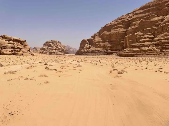 Tan sand and rock formations in southern Wadi Rum